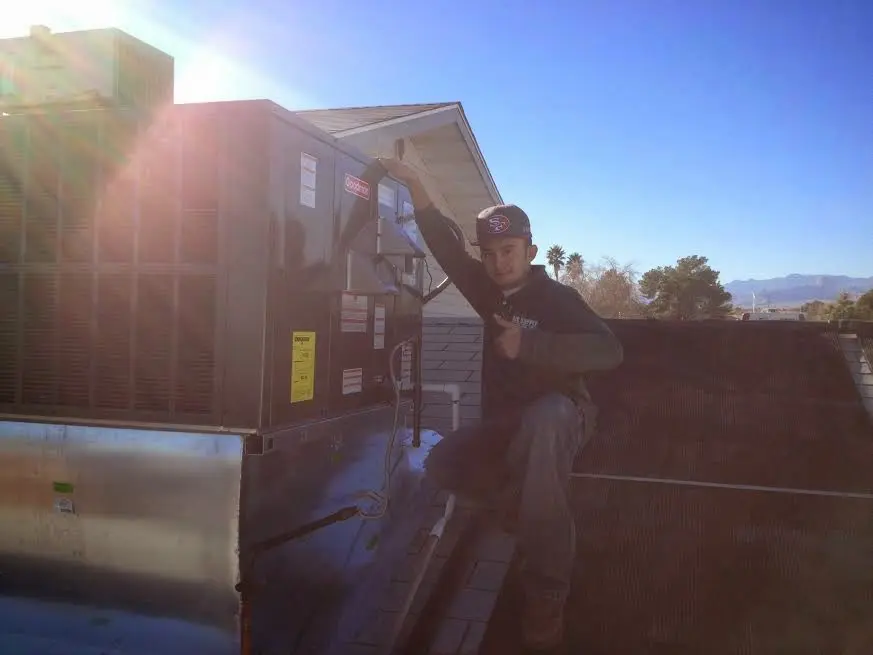 HVAC technician performing Air Duct Repair on a rooftop unit in Westampton