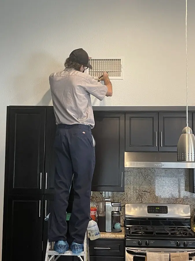 Technician inspecting an air vent during HVAC service in Westampton